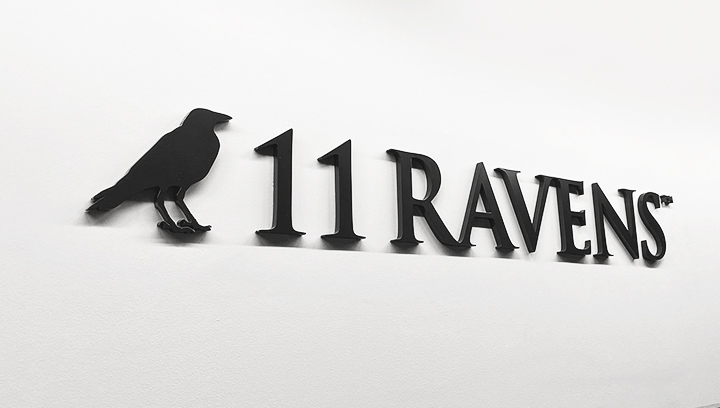 11 Ravens dimensional acrylic business sign in black displaying the brand name and custom logo