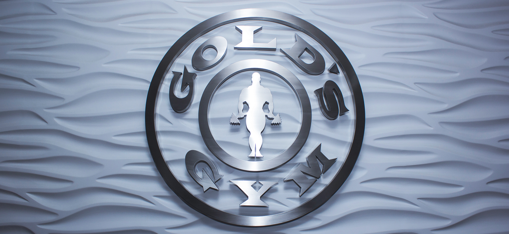Gold's Gym brushed aluminum logo sign in a round shape for branding