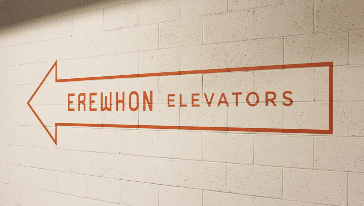 Erewhon interior wayfinding signage made of opaque vinyl for directing to the elevator