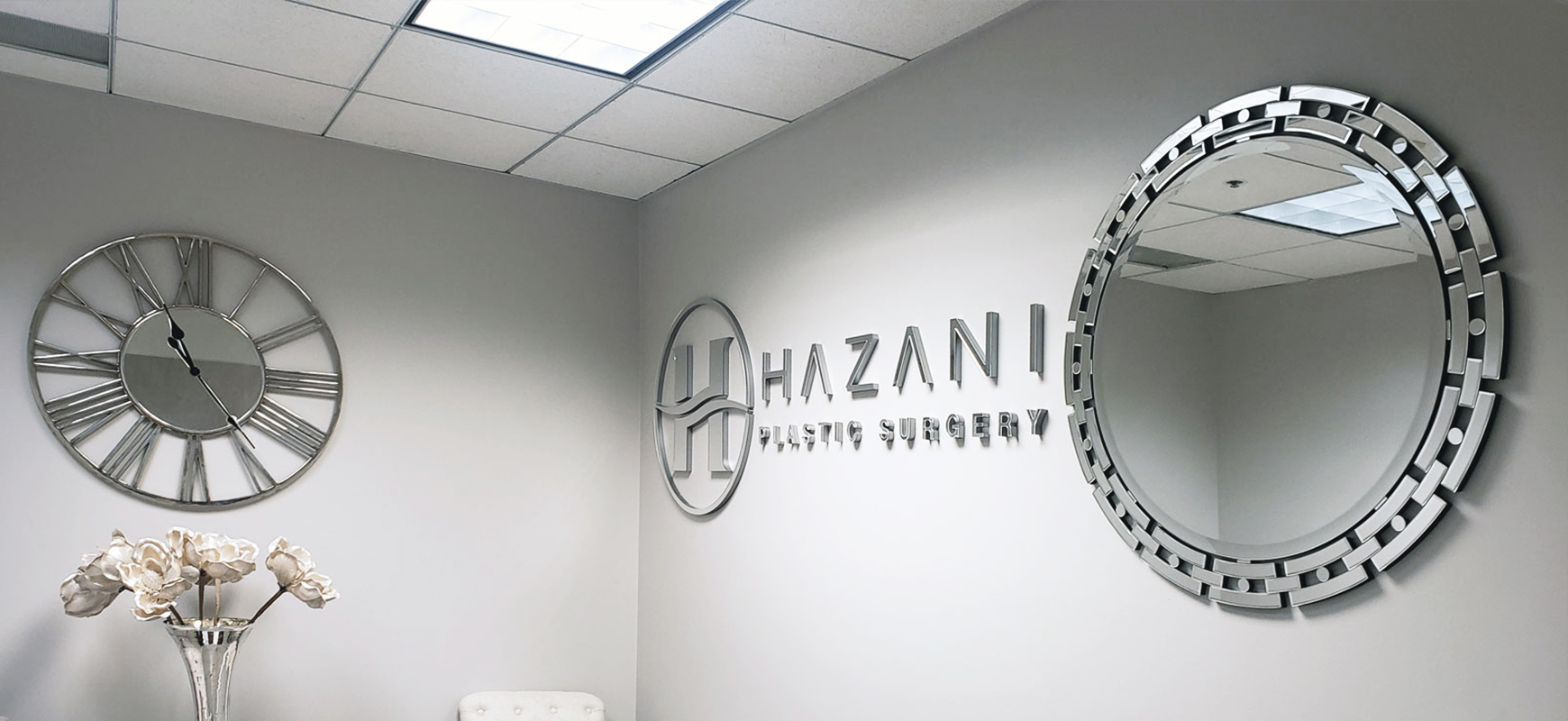 Hazani Plastic Surgery acrylic business sign displaying the brand name and logo