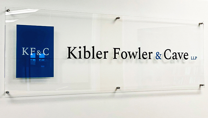 Kibler Fowler & Cave standard acrylic nameplate sign mounted to the office wall