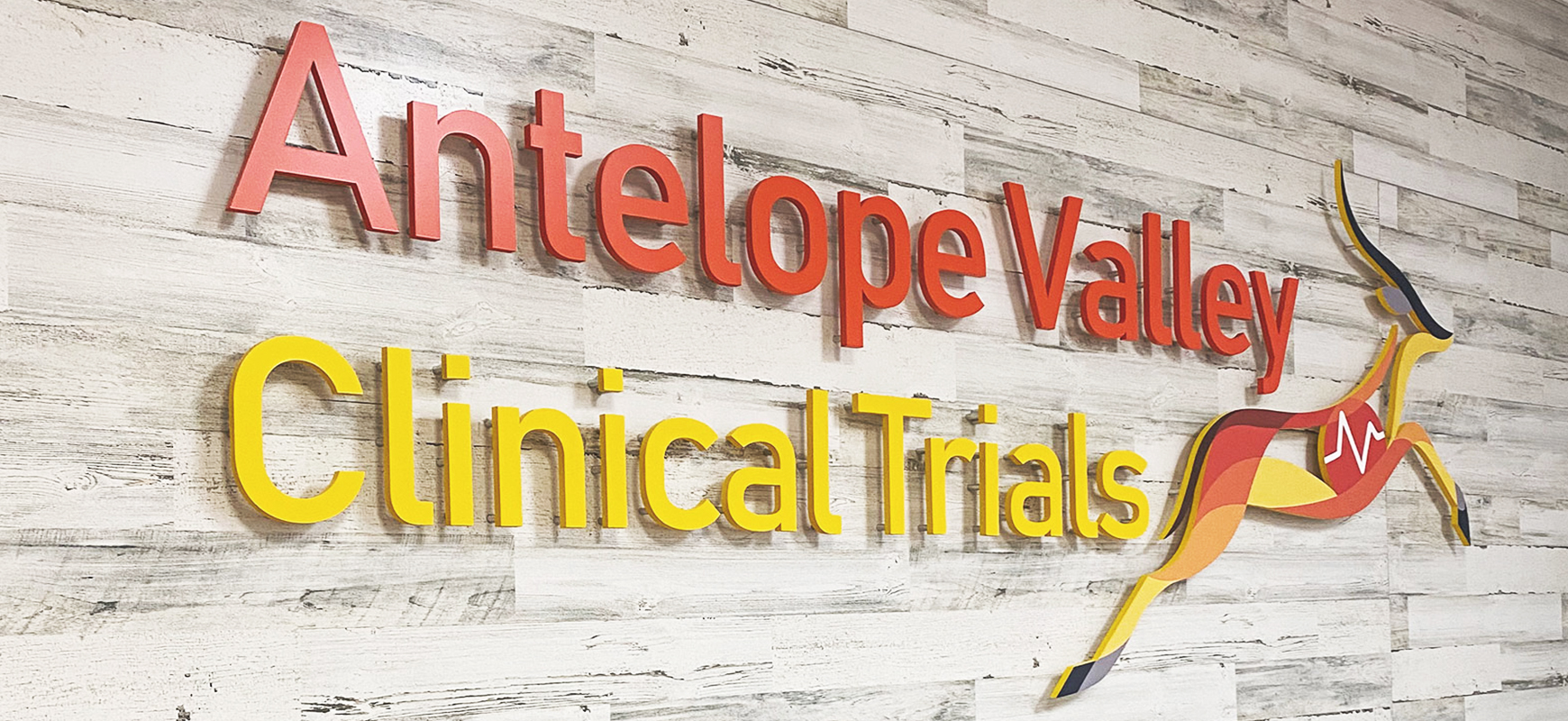 Antelope Valley Clinical Trials PVC sign in yellow and red for office interior branding