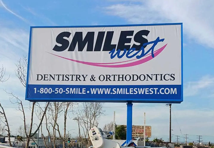 Smiles West pylon sign displaying information about the company made of backlit vinyl