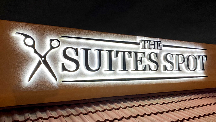 The Suites Spot illuminated aluminum sign displaying the company name and logo