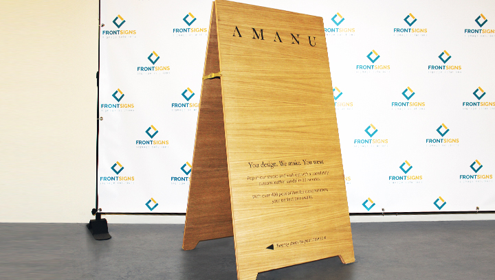 Amanu freestanding wooden sign displaying promotional information for sustainable advertising