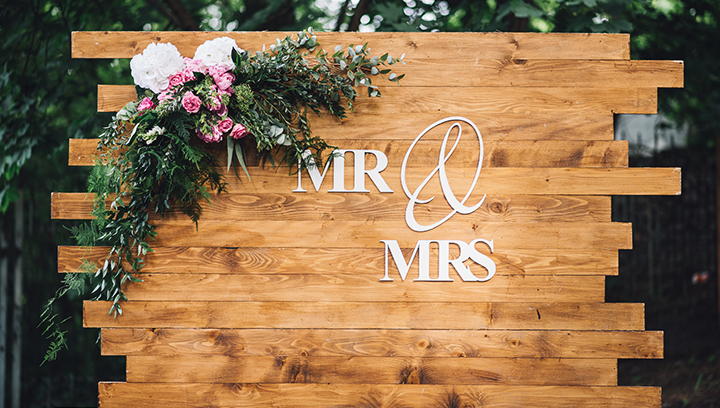 wedding wooden sign displaying the words Mr & Mrs on a custom-made board with flowers
