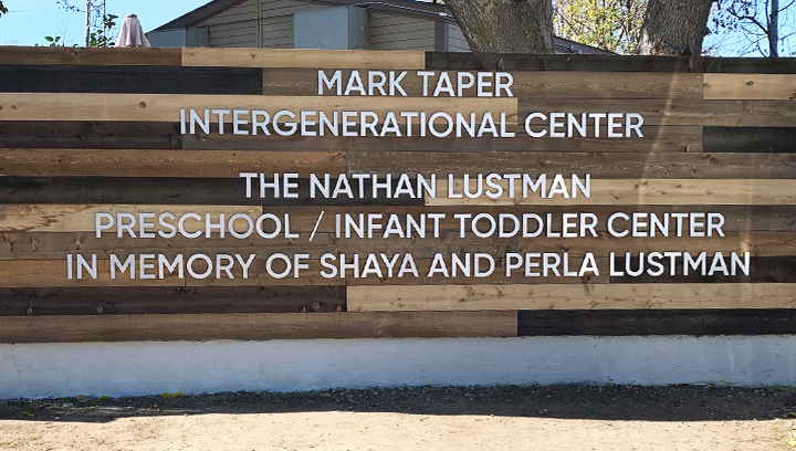 Mark Taper Intergenerational Center outdoor wooden sign with a monumental board