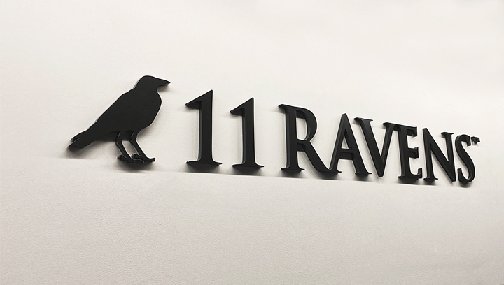 11 Ravens three dimensional letter signage on wall in black made of acrylic displayed on a wall