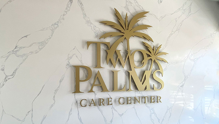 Two Palms Care Center custom signage displaying the brand name and logo with acrylic