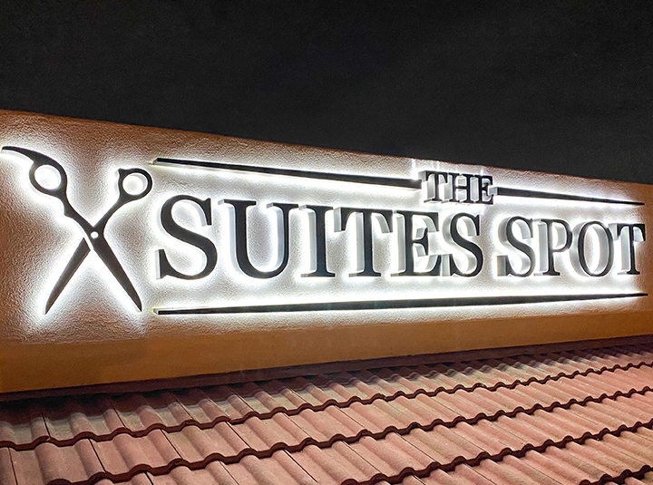 The Suites Spot custom backlit sign with the brand name and logo made of aluminum and acrylic