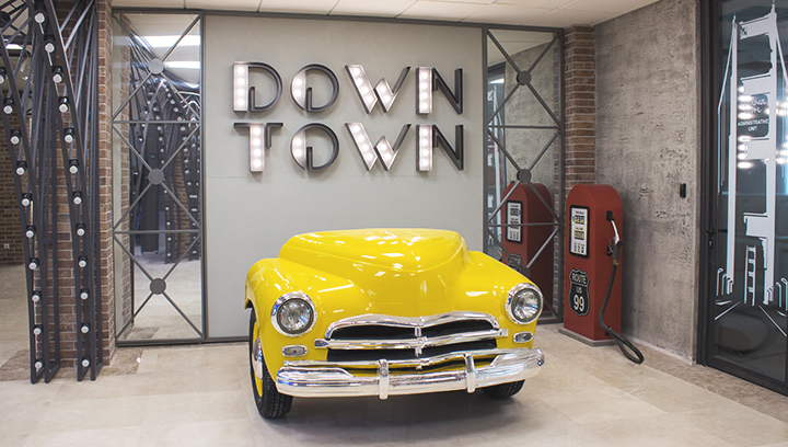 Lobby sign in the form of a retro car made of aluminum and painted in yellow