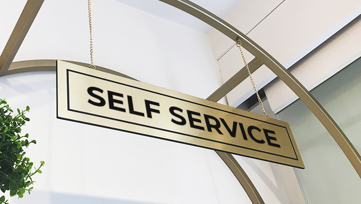 hanging foam core sign in golden color displaying the words Self Service