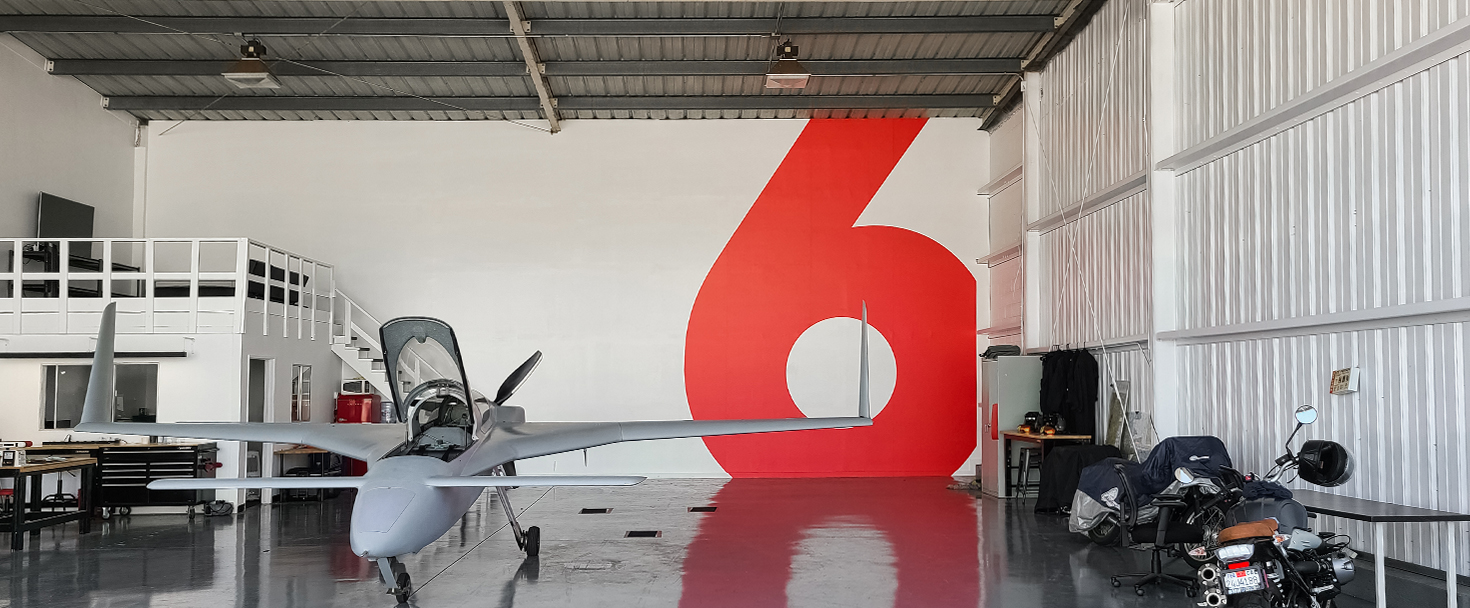 Airplane Hangar wall decal in red displaying the number 6 made of opaque vinyl for branding