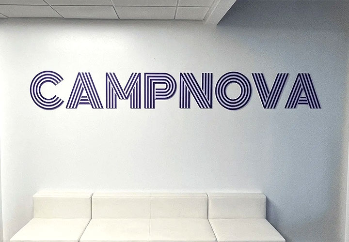 Campnova office lobby sign with a striped font spelling the brand name made of acrylic