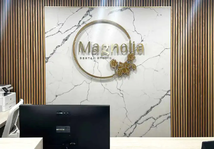 Sophistocated lobby signs for Magnolia Dental Studio displaying the logo on marble stone