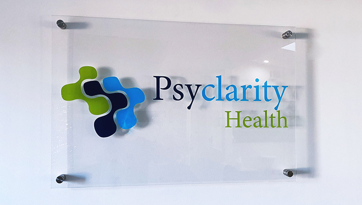 Psyclarity Health plastic lobby sign displaying the company name and logo for office branding