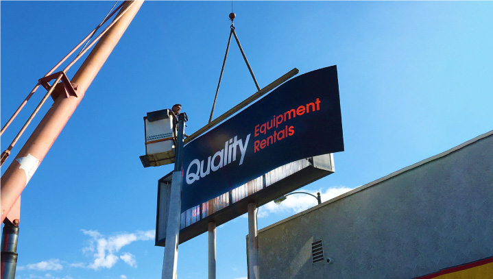 Quality Equipment Rentals metal sign restoration of a tall display with a crane supporting it
