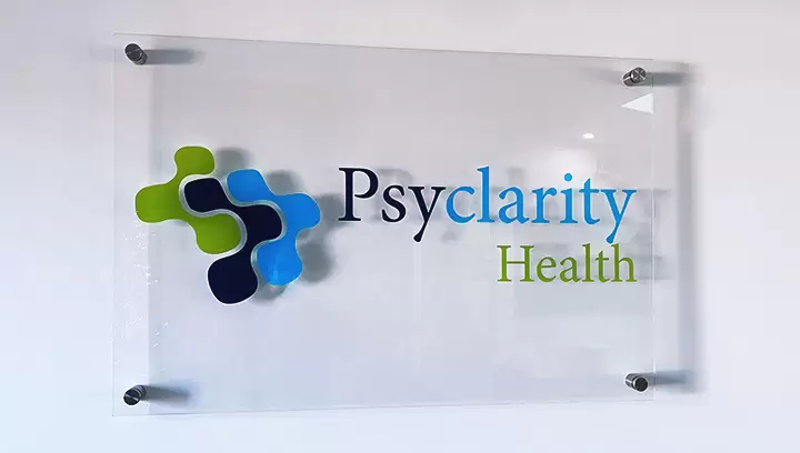 Clear lobby signs for Psyclarity Health displaying the company name and logo