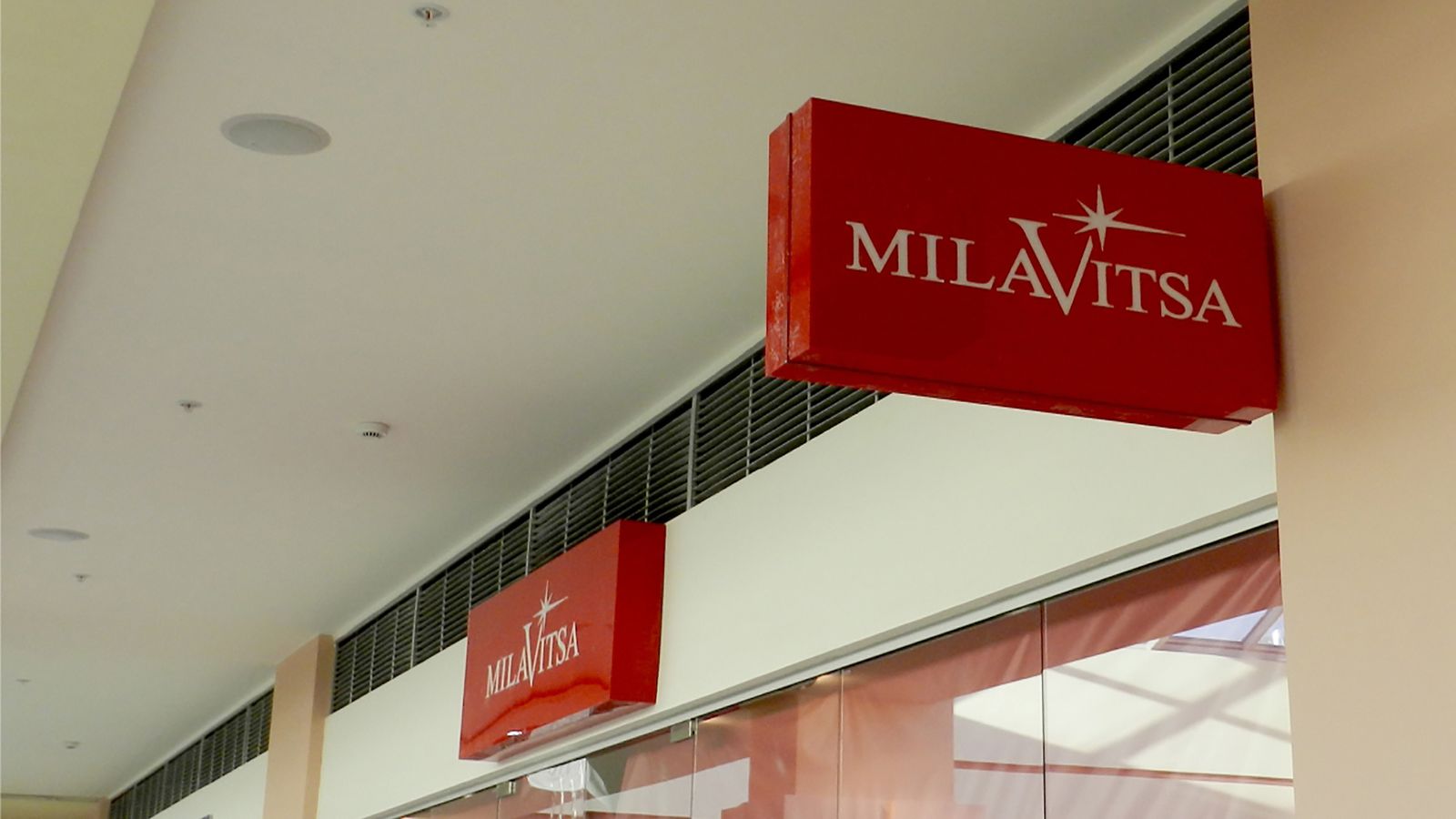 MILAVISTA indoor acrylic light boxes in red color fixed to the wall for storefront branding