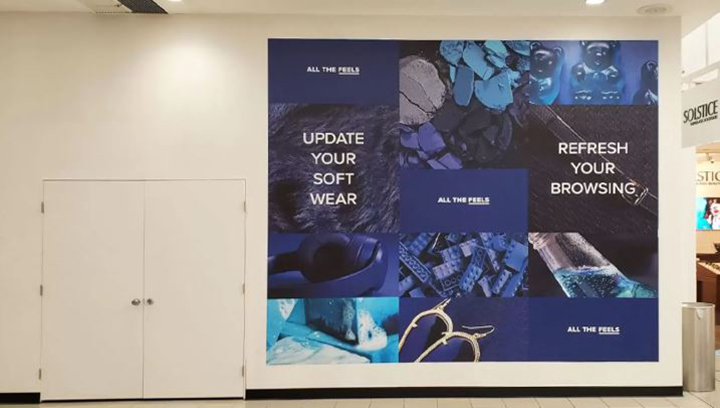 Promotional event sign on a vinyl wall wrap depicting blue graphics for an ad campaign