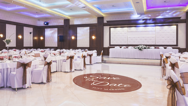 Event sign with the phrase 'Save the Date' on an oval floor decal for a wedding reception hall