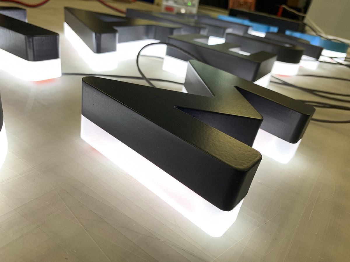 Backlit 3d acrylic letters painted in black color displayed on the table before installation
