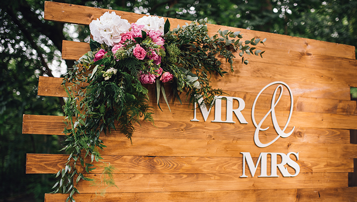 wedding event sign displaying the words Mr & Mrs on a custom shaped wooden board