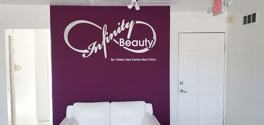 Ý tưởng thiết kế tường văn phòng công ty từ Infinite Beauty hiển thị tên thương hiệu