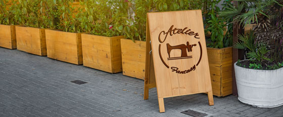 Atelier Fantasy sandwich board design with cool wood cut patterns