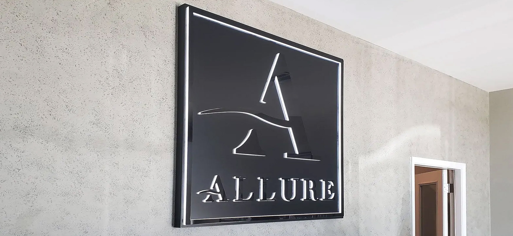 Allure halo-lit signs displaying the brand name and logo made of aluminum and acrylic