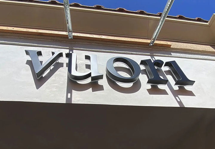 Vuori halo-lit sign in black displaying the brand name made of aluminum and acrylic