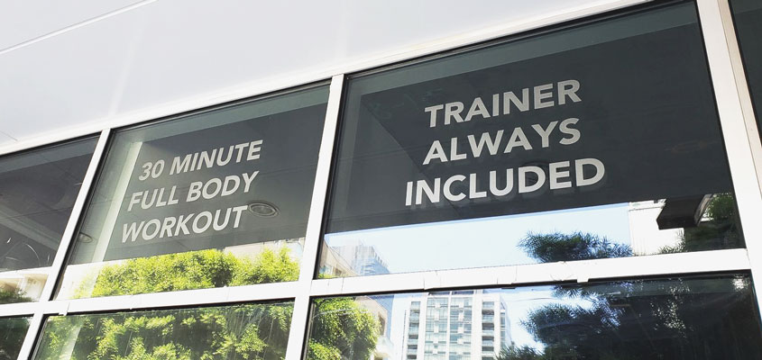 Vinyl sign design idea displayed on a gym window showcasing business services