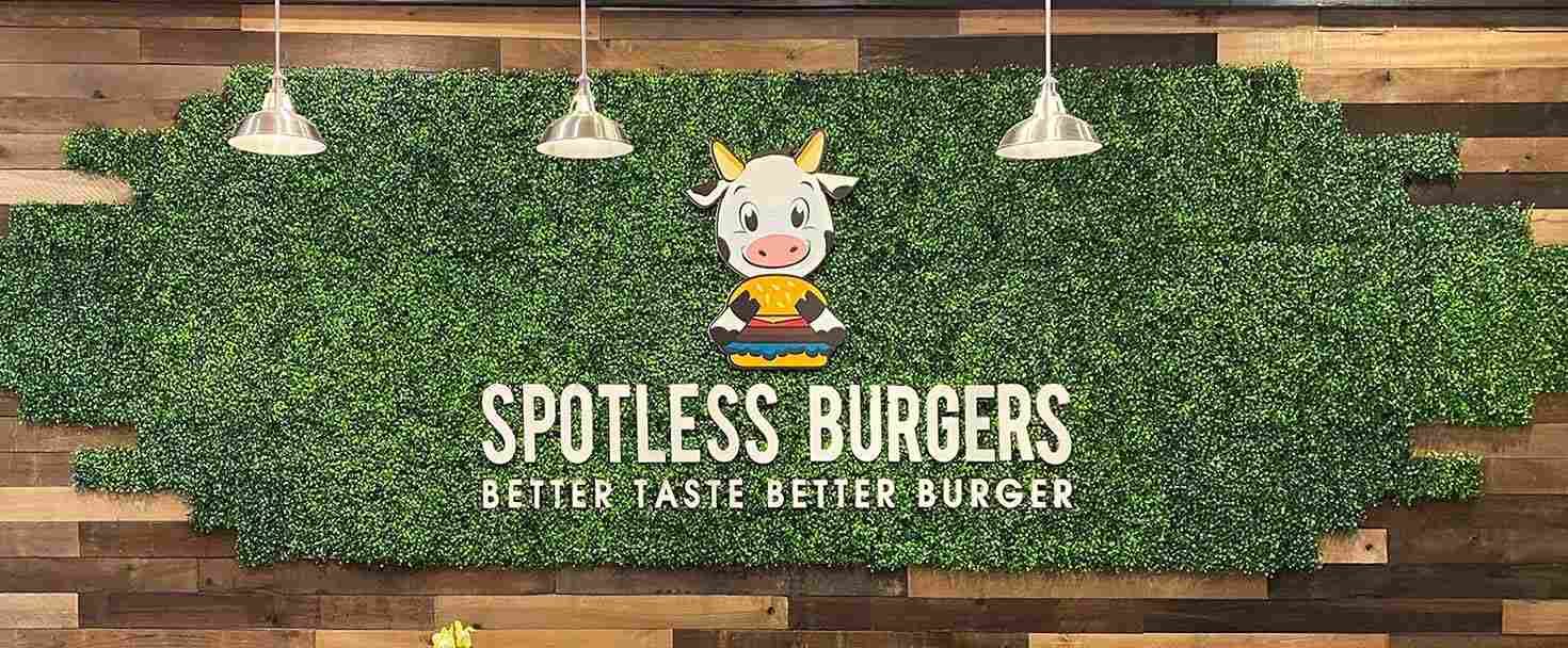 Spotless Burgers restaurant sign displaying the brand name, slogan and cow logo made of PVC