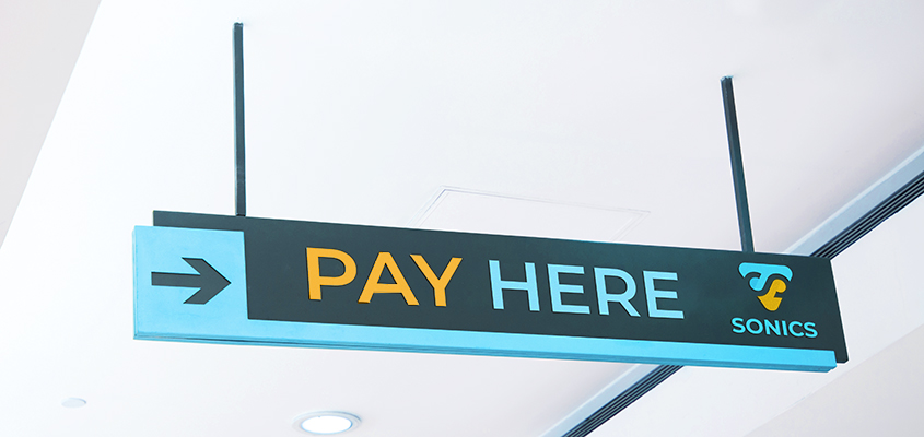 'Pay Here' sign with the brand's name as a corporate branding element