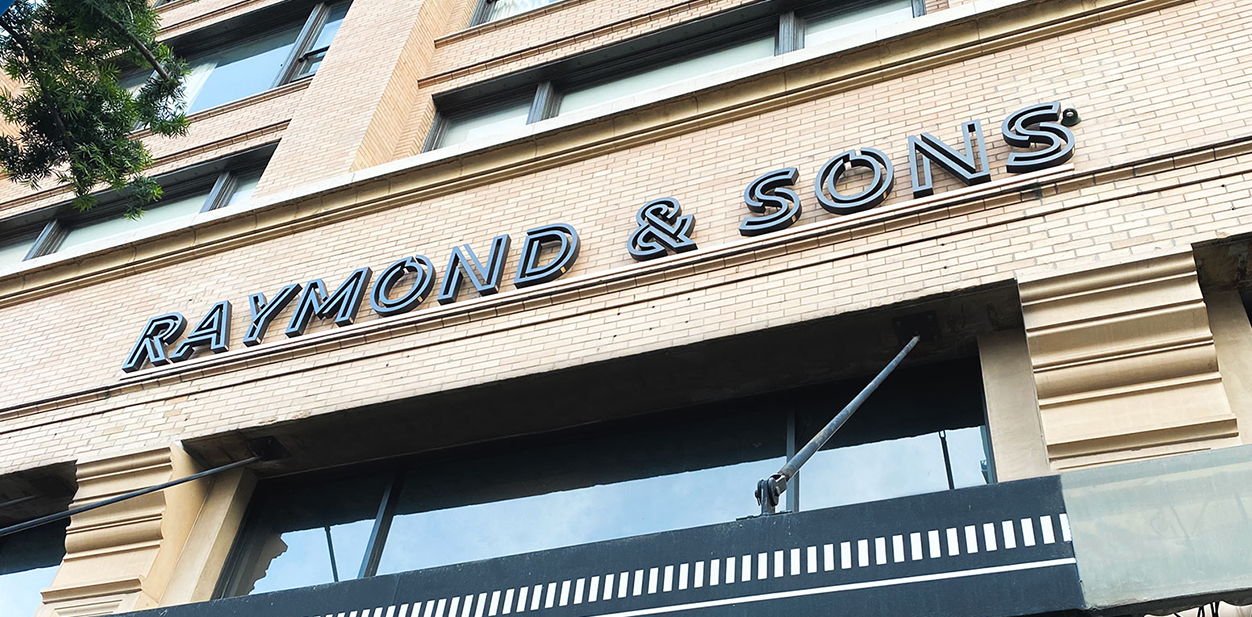 Raymond & Sons storefront branding with metal materials