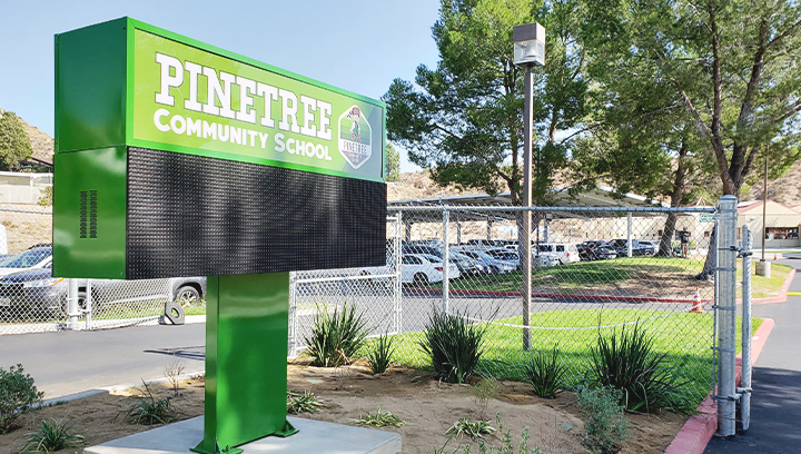 Pinetree Community School green pylon sign in a monument sign style made of aluminum
