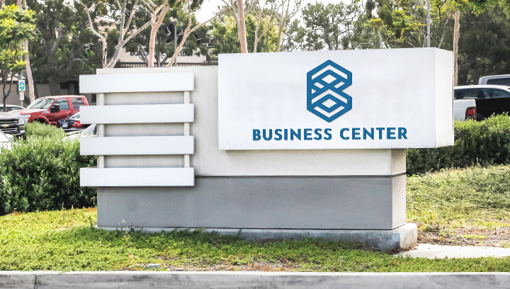 business entrance monument sign displaying the company name and logo outdoors