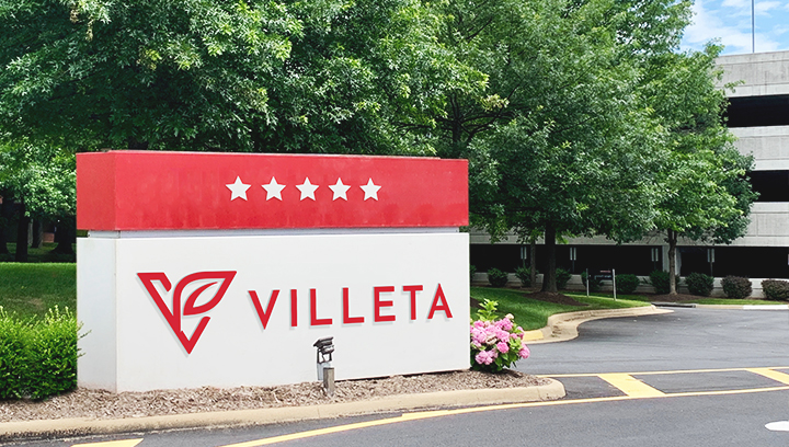 Villeta hotel monument sign in red and white displaying the brand name and logo