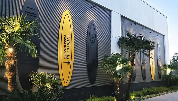 Building signage for California Pizza Kitchen in the shape of surfboards, made of aluminum
