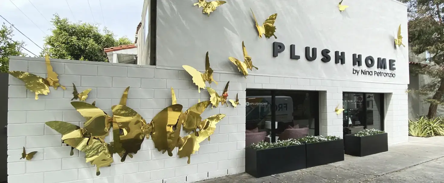 Building sign for Plush Home with decorative butterfly ornaments made of aluminum