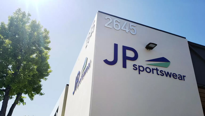 JP Sportswear exterior building top sign displaying the brand name and logo made of aluminum