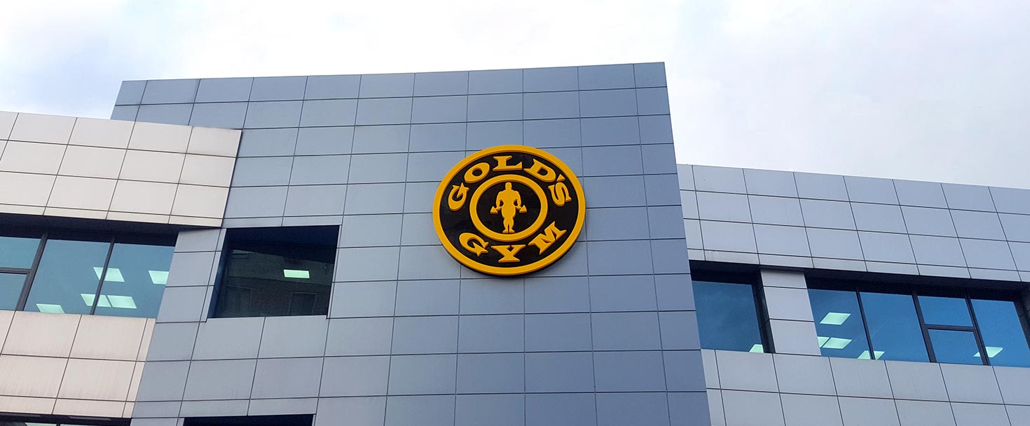 Gold's Gym high rise sign as a round shape logo made of aluminum and acrylic for branding