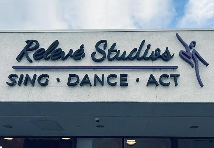 Relevé Studios exterior building sign with the brand name and logo made of lexan and aluminum