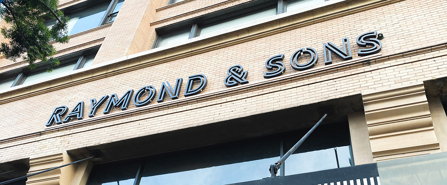 Raymond & Sons business building sign displaying the brand name made of aluminum