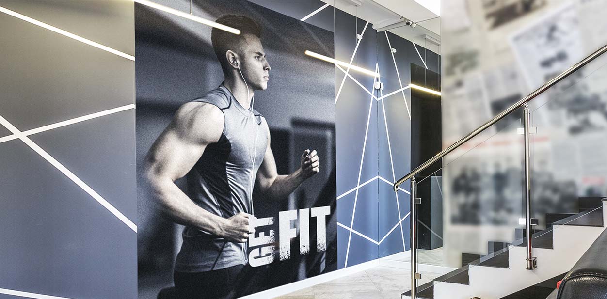 Gym lobby wall design idea with a photograph display and illumination