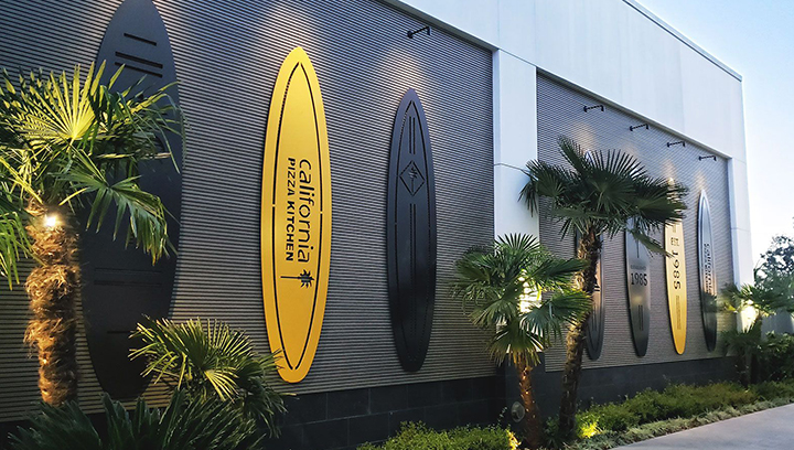 California Pizza Kitchen metal outdoor signs in yellow and black surfboard shapes