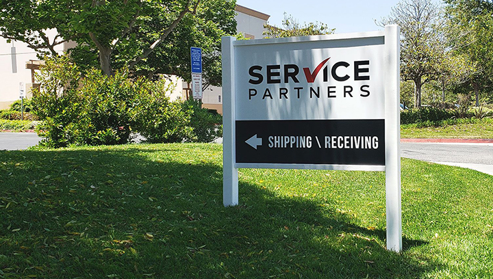 Service Partners free-standing outdoor sign made of Dibond and wood displayed at the yard