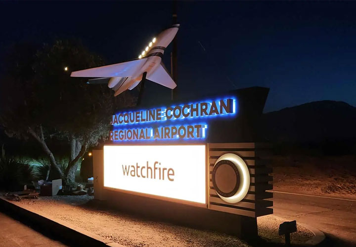 Illuminated outdoor sign with large digital display and model aircraft, made of aluminum