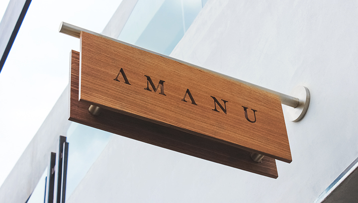 Amanu wooden outdoor sign displaying the brand name in an engraved style