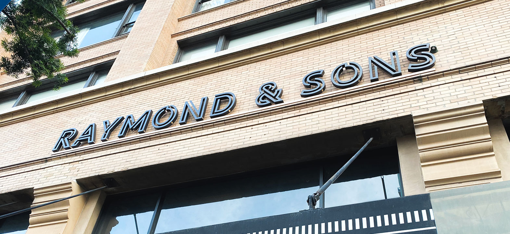 Raymond and Sons outdoor architectural signage made of aluminum for storefront branding